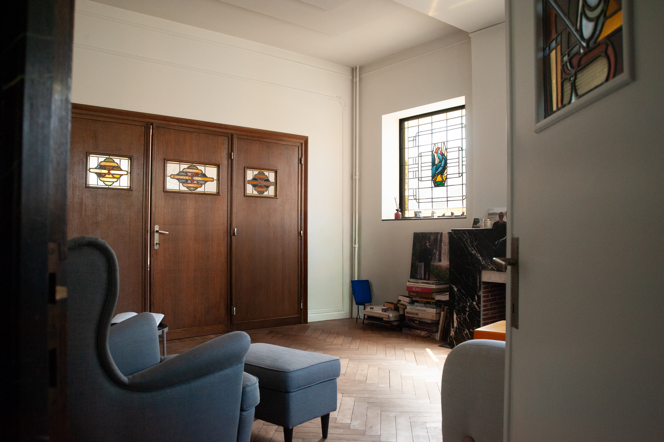 Het salon met glasramen en visgraatparket.